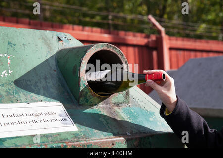 Hand putting bottle in recycling bin Stock Photo