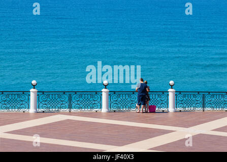 Love couple standing on a terrace in a Turkish resort, above mediterranean sea. Stock Photo
