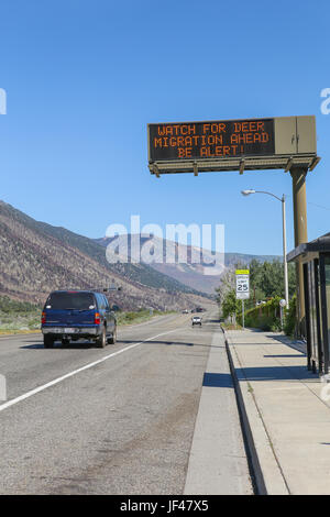 Road sign information for motorists along highway 395 in Lee Vining California warning of migrating deer crossing the road. Stock Photo