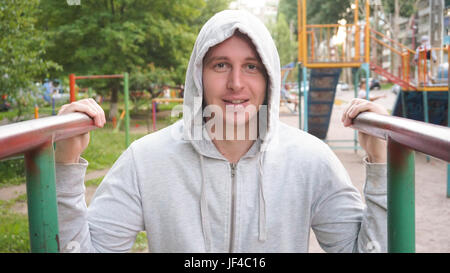 A strong, healthy man, doing pullups on the bars Park Sunrise workout, Stock Photo