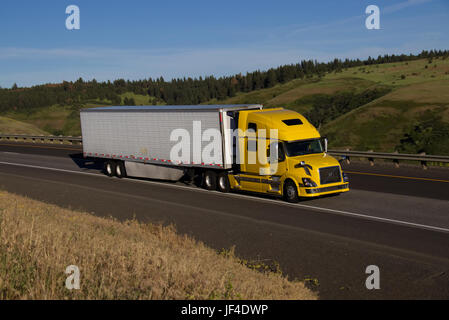 Yellow Volvo Semi-Truck / White Unmarked Trailer Stock Photo