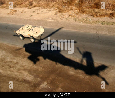 Fly Army! Photo by Department of the Army January 09, 2007  The shadow of an AH-64 Apache helicopter is a reminder that this convoy in Iraq is well protected.  Related: Fly Army! Stock Photo