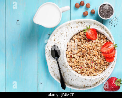 bowl with muesli, fresh strowberry, nuts, chia seeds and milk Stock Photo
