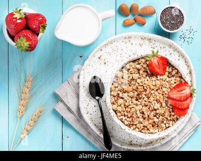 bowl with muesli, fresh strowberry, nuts, chia seeds and milk Stock Photo