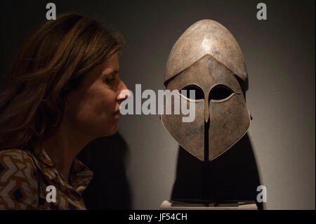 London, UK.  29 June 2017.  A woman views a 6th/5th century BC Greek bronze Corinthian Helmet.  Members of the public visit Masterpiece London, a leading art fair held in the grounds of the Royal Hospital Chelsea.  The fair brings together 150 international exhibitors presenting works from antiquity to the present day and runs 29 June to 5 July 2017.   Credit: Stephen Chung / Alamy Live News Stock Photo