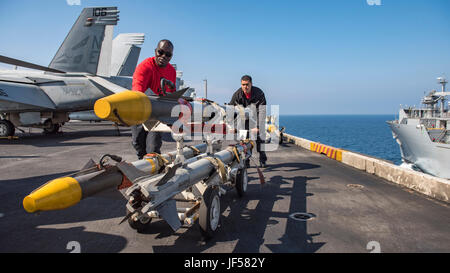 170525-N-BL637-018  PACIFIC OCEAN (May 25, 2017) Aviation Ordnanceman 2nd Class Marvin Masolo, from Louisville, Ky. left, and Aviation Ordnanceman 3rd Class Derrick Scott, from Houston, transport ordnance during a vertical replenishment-at-sea between the Lewis and Clark-class dry cargo and ammunition ship USNS Wally Schirra (T-AKE 8) and the Nimitz-class aircraft carrier USS Carl Vinson (CVN 70) in the western Pacific region. The U.S. Navy has patrolled the Indo-Asia-Pacific routinely for more than 70 years promoting regional peace and security. (U.S. Navy photo by Mass Communication Speciali Stock Photo