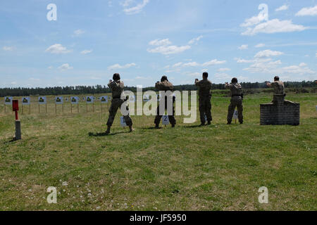 Battle Group Poland U.S. and U.K. soldiers fire the Polish P-83 pistol as they compete in a small arms shooting competition during a Polish Veterans Day event near Bemowo Piskie Training Area May 27. The multinational battle group is in Poland as part of NATO’s enhanced Forward Presence and the soldiers of the unit have been very active with the nearby communities all as a way to make the citizens aware of their presence and to learn about the battle group’s mission. (U.S. Army photo by Spc. Kevin Wang/Released) Stock Photo