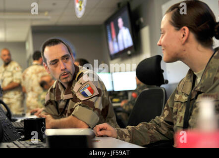 A member of the French air force speaks with a U.S. Airman in the Combined Air Operation Center May 27, 2017, at Al Udeid Air Base, Qatar. The Coalition Forces in the CAOC are responsible for command and control of air power within the Central Command area of responsibility. (U.S. Air Force photo by Staff Sgt. Desiree Economides) Stock Photo