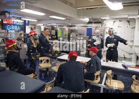 170527-N-FQ994-064 MEDITERRANEAN SEA (May 27, 2017) A team of Sailors within Repair Locker 5 discuss an active integrated training team  scenario aboard the Arleigh Burke-class guided-missile destroyer USS Ross (DDG 71) May 27, 2017. Ross, forward-deployed to Rota, Spain, is conducting naval operations in the U.S. 6th Fleet area of operations in support of U.S. national security interests in Europe and Africa. (U.S. Navy photo by Mass Communication Specialist 3rd Class Robert S. Price/Released) Stock Photo