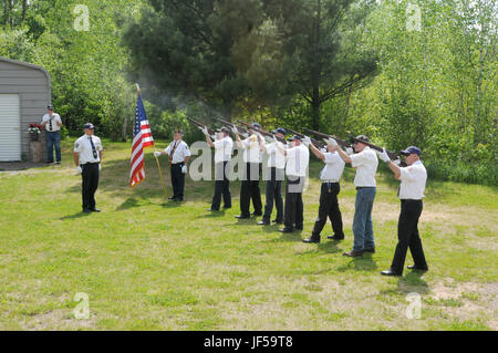 An honor guard comprised of members of the local American Legion and Veterans of Foreign Wars posts provide a 21-gun salute to honor World War II veteran Pfc. Herbert A. Grue at an awards presentation May 28 in Birchwood, Wisconsin. Grue was killed in action November 16, 1942, and his awards and medals were presented to his surviving family members during the ceremony. Stock Photo