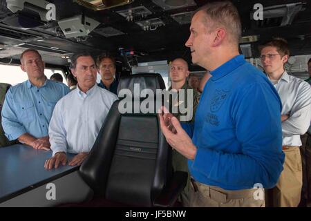 170529-N-VM650-498 - WESTERN PACIFIC (May 29, 2017) Rear Adm. Charles Williams, commander, Task Force 70, talks to U.S. Congressmen (left to right) Ted Budd (R-NC), Gary Palmer (R-AL) and Mike Bishop (R-MI) in primary flight control aboard the Navy's forward-deployed aircraft carrier, USS Ronald Reagan (CVN 76). Ronald Reagan, the flagship of Carrier Strike Group 5, provides a combat-ready force that protects and defends the collective maritime interests of its allies and partners in the Indo-Asia-Pacific region. (U.S. Navy photo by Mass Communication Specialist 3rd Class Charles J. Scudella I Stock Photo