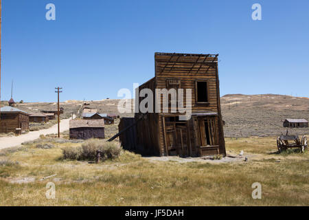 Several abandoned homes and shops along a dirt road in Bodie Ghost Town. Stock Photo