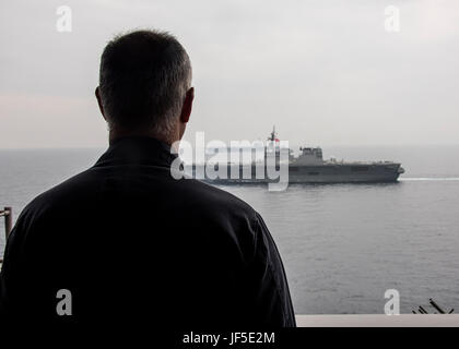 170601-N-LK571-225 SEA OF JAPAN (June 01, 2017) Capt. Doug Verissimo, commanding officer of the Nimitz-class aircraft carrier USS Carl Vinson (CVN 70), observes the Japanese Ship (JS) Hyuga (DDH 181), front, and the Nimitz-class aircraft carrier USS Ronald Reagan (CVN 76) during a photo exercise. Japan Maritime Self Defense Force (JMSDF) and U.S. Navy forces routinely train together to improve interoperability and readiness to provide stability and security for the Indo-Asia Pacific region.  (U.S. Navy photo by Mass Communication Specialist 3rd Class Matthew Granito/Released) Stock Photo