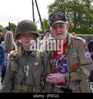 World War II veteran Ernie Lamson, 95, poses with a combat medic reenactor before the Kenneth Moore and Robert Wright memorial ceremony, June 3, 2017, in Angoville-au-Plain, France.   This ceremony commemorates the 73rd anniversary of D-Day, the largest multi-national amphibious landing and operational military airdrop in history, and highlights the U.S.' steadfast commitment to European allies and partners. Overall, approximately 400 U.S. service members from units in Europe and the U.S. are participating in ceremonial D-Day events from May 31 to June 7, 2017. Stock Photo