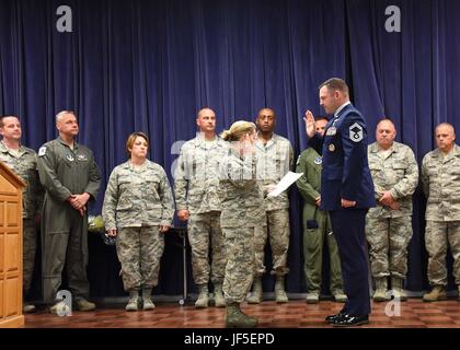 NEW CASTLE AIR NATIONAL GUARD BASE, Del.- Chief Master Sergeant Shaune Peters, command chief, 166th Airlift Wing, recites the “Chief’s Charge” with Senior Master Sergeant Summer Brown, superintendent, 166th Operations Group, in the presence of the 166th Airlift Wing Chief Master Sergeants on June 3, 2017. A ceremony was held at the Delaware National Guard’s Headquarters building to commemorate the promotion of Brown to the rank of Chief Master Sergeant. (U.S. Air National Guard photo by Tech. Sgt. Gwendolyn Blakley/ Released). Stock Photo