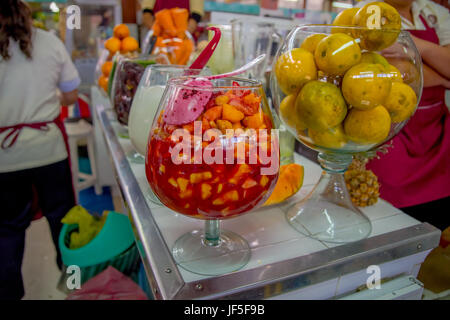 QUITO, ECUADOR - NOVEMBER 23, 2016: Fruit salad and orange fruits inside of a big glass cup, at the municipal market located in Saint Francis in the c Stock Photo