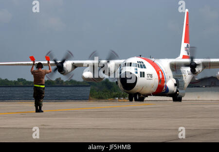 050121-F-4884R-010   Airman 1st Class Ryan Aldrich directs a U.S. Coast Guard HC-130 Hercules at Utapao Naval Air Station, Thailand, on Jan. 21, 2005.  More than 14,000 U.S. service members are deployed to various regions of Southeast Asia supporting Operation Unified Assistance, working with international militaries and non-governmental organizations to aid those affected by the Dec. 26, 2004, Indian Ocean tsunami. Aldrich is a C-130 crew chief from the 374th Aircraft Maintenance Squadron, Yokota Air Base, Japan.  DoD photo by Tech. Sgt. Scott Reed, U.S. Air Force. (Released) Stock Photo