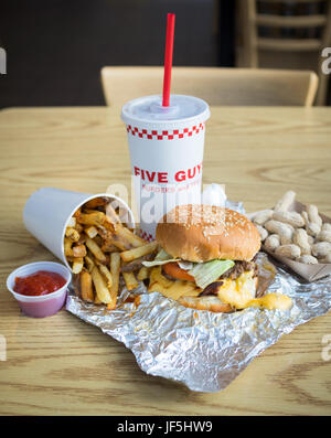 A bacon cheeseburger, French fries, and peanuts from Five Guys Burgers and Fries, an American fast casual restaurant chain. Stock Photo