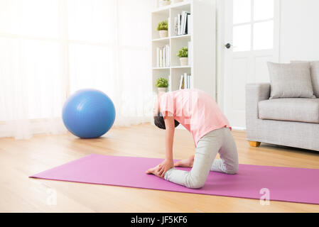 side view of girl children practicing yoga action, kneel down in exercise room doing yoga pose working out wearing sportswear indoor at space backgrou Stock Photo