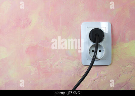 White socket and cable on pink wall. Stock Photo
