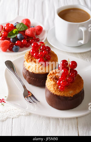 Beautiful coconut muffins with red currants and coffee close-up on the table. vertical Stock Photo
