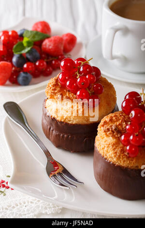 Coconut muffins with currants and coffee with milk close-up on the table. Vertical Stock Photo