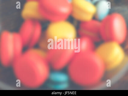 Bright macaroons in a glass bowl. Defocused shot Stock Photo
