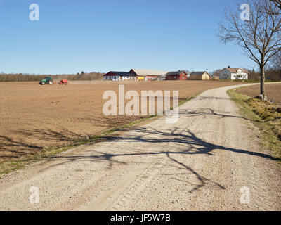 Dirt track, tractor on field on background Stock Photo