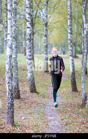 Young woman jogging in forest Stock Photo