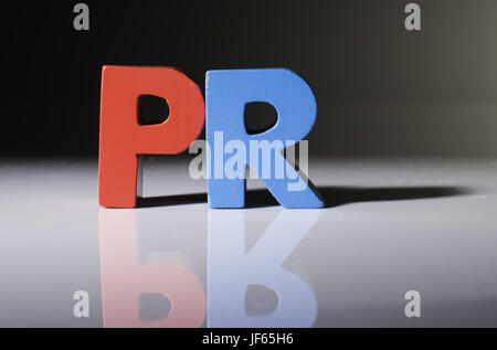 Multicolored word PR made of wood. Stock Photo