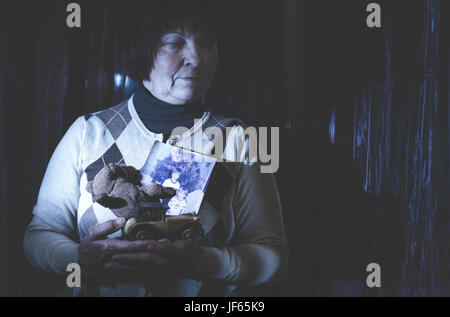 Senior woman hold pictures Stock Photo