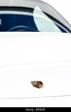 View of white Porsche car on white background, logo and brand name on the hood Stock Photo