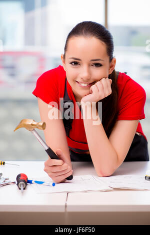 Young woman in coveralls doing repairs Stock Photo