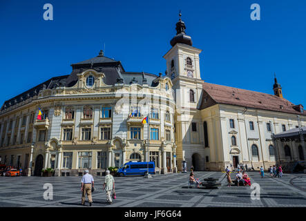 City Hall building and Holy Trinity Roman Catholic Church (Biserica Sfanta Treime) on Large Square in Historic Center of Sibiu city, Romania Stock Photo