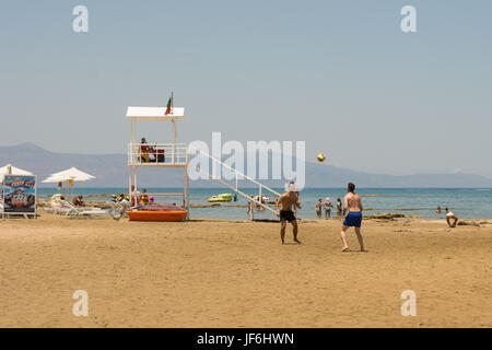 Young men playing beach football on the beach at Agia Marina, Crete, Greek Islands, Greece Stock Photo