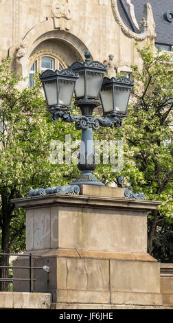 Decorative street lamp made of cast iron on the background of a flowering tree. Budapest. Hungary Stock Photo