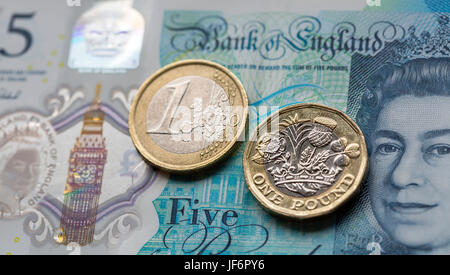 European Currency - Five Pound Note with the New 2017 Pound Coin and One Euro Coin Stock Photo