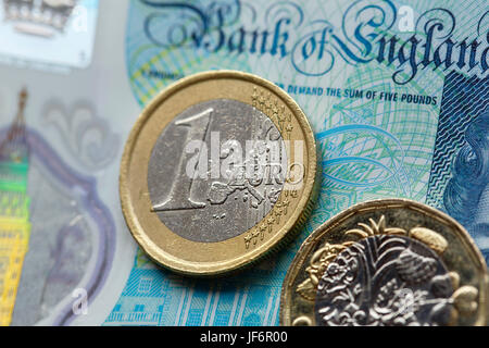 European Currency - Five Pound Note with the New 2017 Pound Coin and One Euro Coin Stock Photo