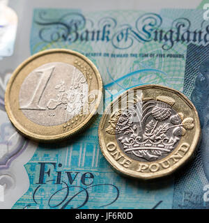 European Currency - Five Pound Note with the New 2017 Pound Coin and One Euro Coin Stock Photo