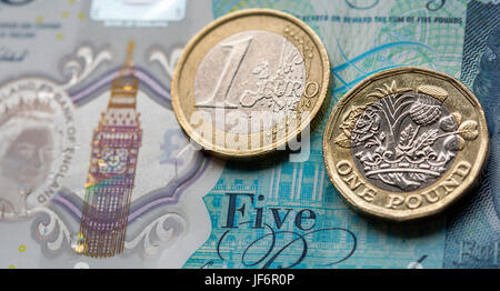 European Currency - Five Pound Note with the New 2017 Pound Coin and One Euro Coin Stock Photo