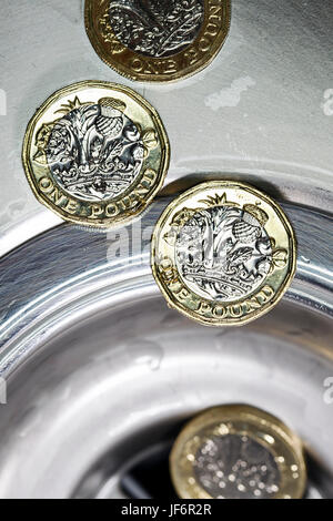 New One Pound Coin going down the Drain - 2017 Stock Photo