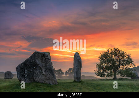 The clouds part as dawn breaks over the ancient Sarsen Stones at Avebury in Wiltshire on the day before the Summer Solstice. Stock Photo