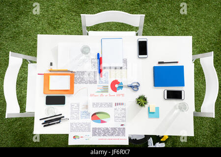 Top view of smartphones with blank screens, papers and office supplies at workplace Stock Photo