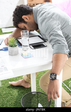 Young african american businessman sleeping on the table at modern office Stock Photo