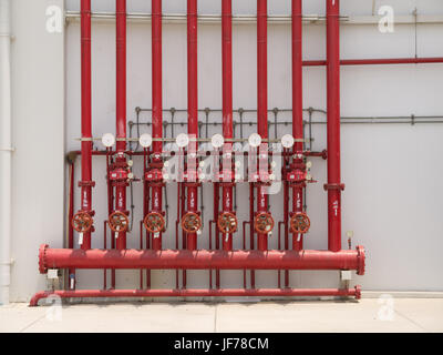 A row of red color fire fighting water supply pipeline system. Stock Photo