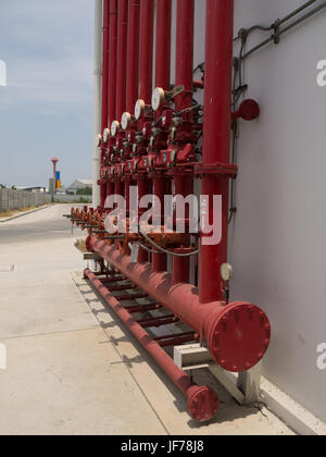 A row of red color fire fighting water supply pipeline system. Stock Photo