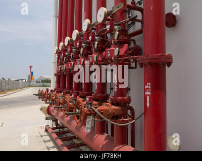 A row of red color fire fighting water supply pipeline system. Stock Photo