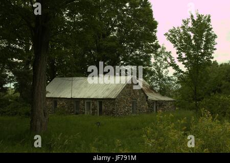 Old Stone Cottage Nestled In The Trees Stock Photo