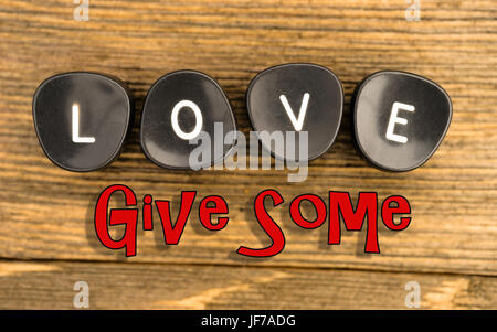 Black typewriter keys laying on wood table say the word love Stock Photo