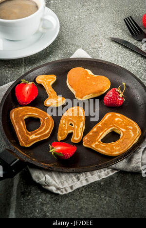 Celebrating Father's Day. Breakfast. The idea for a hearty and delicious breakfast: pancakes in form of congratulations - I love dad. In a frying pan, Stock Photo